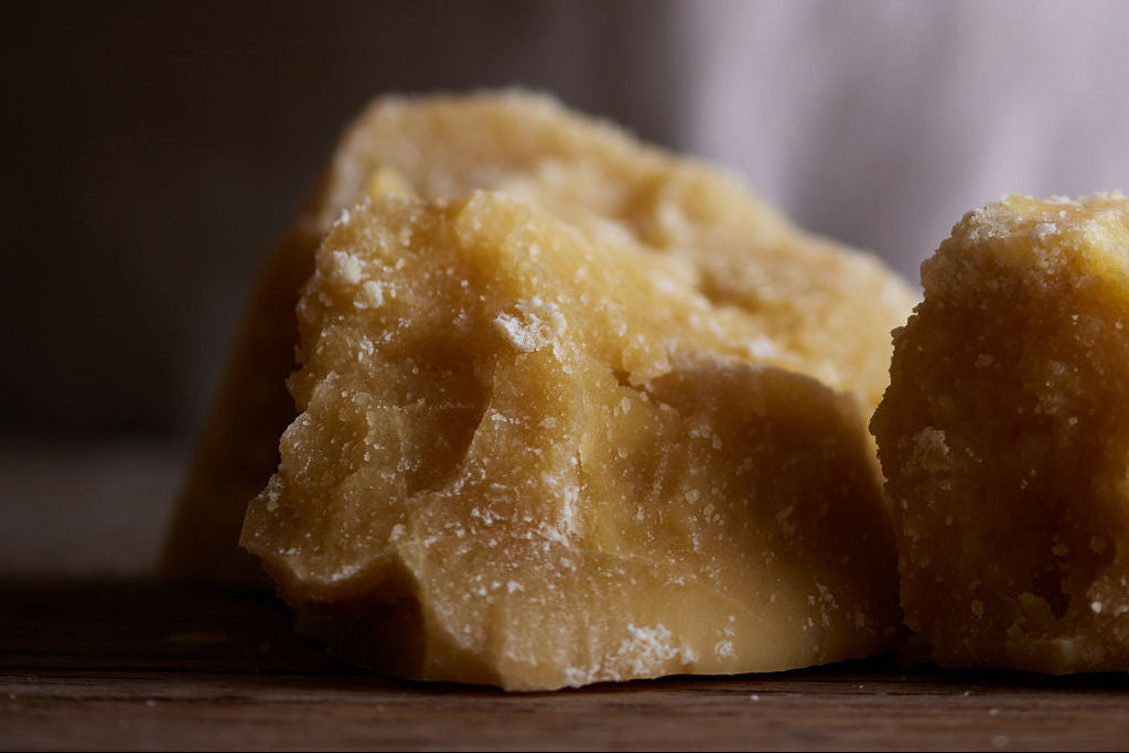Close-up of natural beeswax blocks on a wooden table in the Olieve & Olie factory.