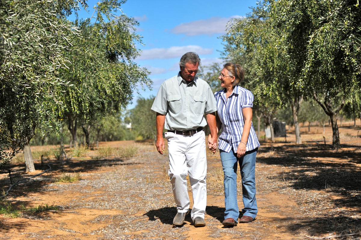 Andy and Jude walking hand in hand through the original olive grove where Olieve & Olie began