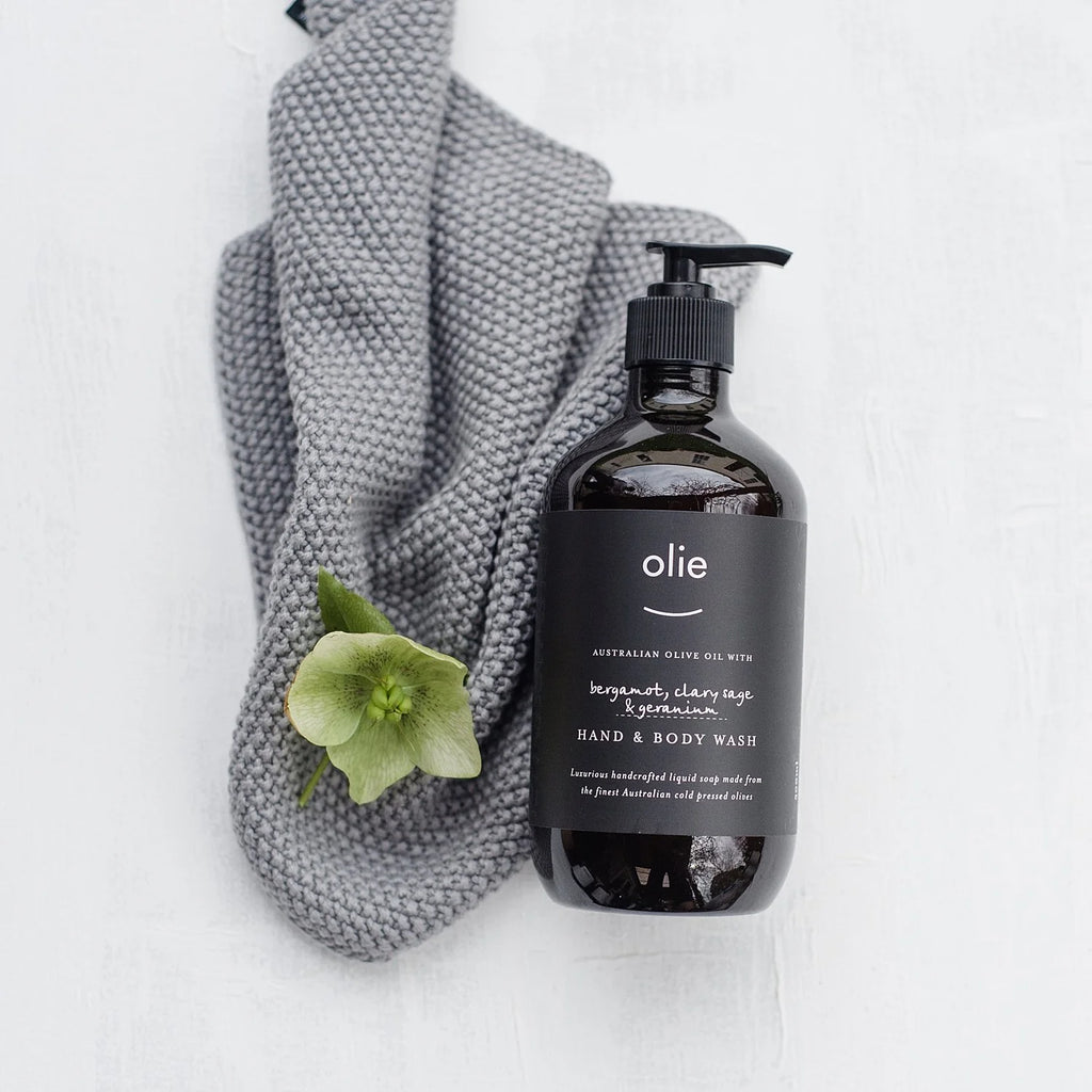Olieve & Olie Bergamot, Clary Sage & Geranium Hand & Body Wash displayed on a white background with a soft knitted washcloth. Handcrafted with Australian olive oil, this gentle liquid soap cleanses without stripping the skin, leaving hands and body soft, refreshed and comfortably moisturised