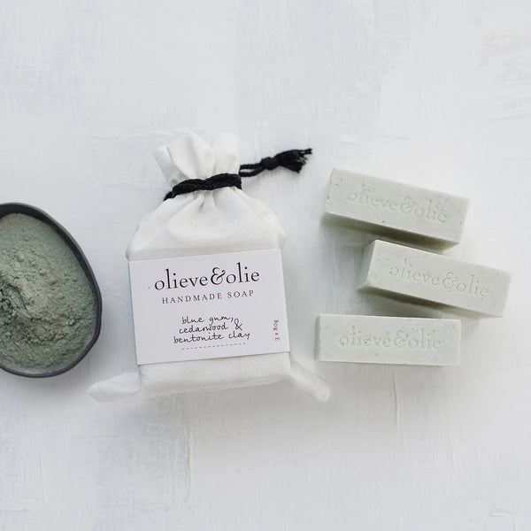 Olieve & Olie Blue Gum, Cedarwood & Bentonite Clay Handmade Bar Soap 3 Pack presented in a white calico bag on a white background. Three handcrafted olive oil soaps made using the traditional cold process method, beautifully packaged for gifting or everyday use