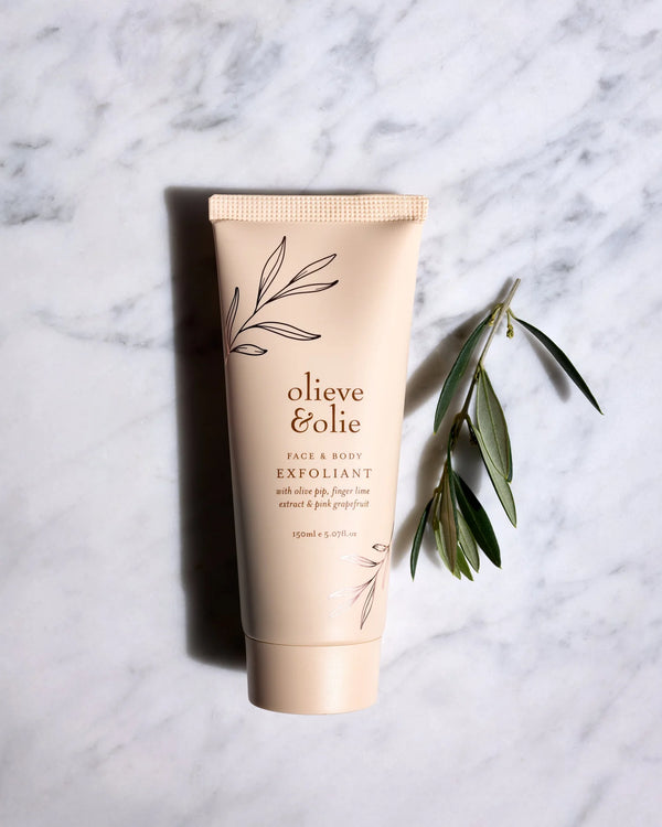 Olieve & Olie Face & Body Exfoliant displayed on a marble table. This gentle exfoliating scrub is handcrafted with natural ingredients to polish away dull skin, leaving the face and body feeling smooth, soft and refreshed