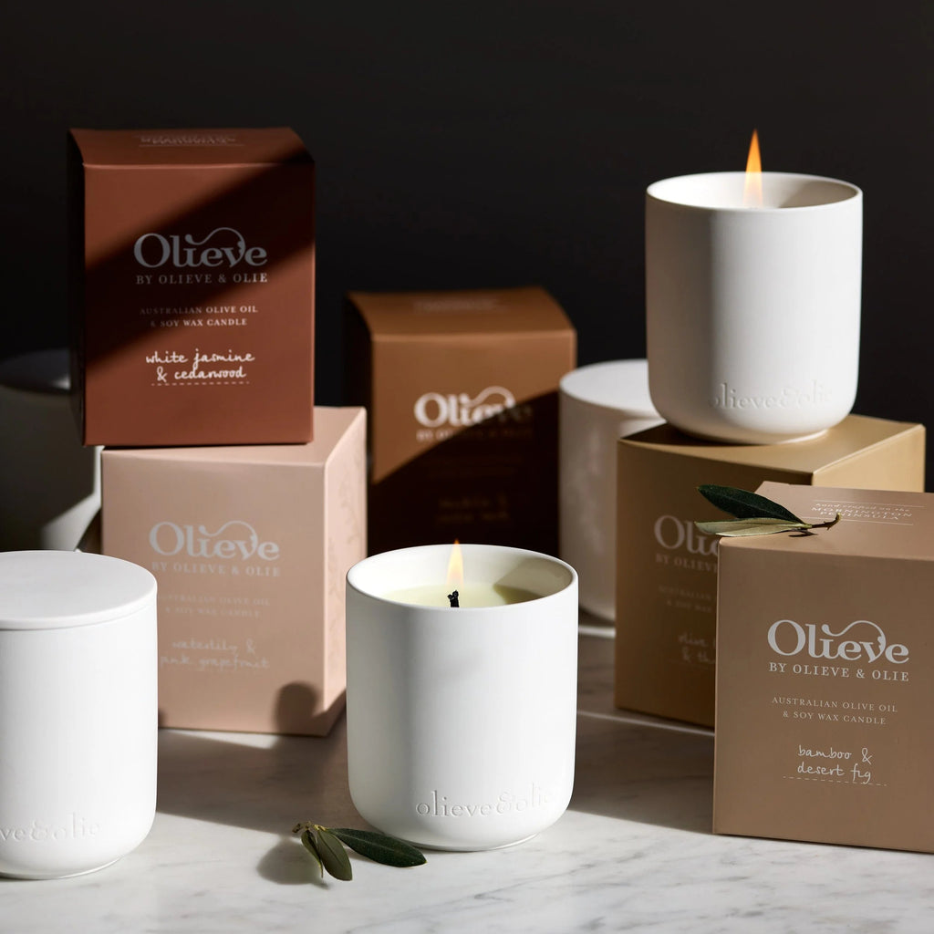 Olieve & Olie handmade candles displayed with their packaging on a marble surface