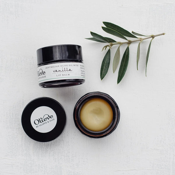 Olieve & Olie Vanilla Lip Balm photographed in a flat lay on a white background. Made with Australian olive oil and beeswax, this nourishing lip balm helps keep lips soft, smooth and deeply hydrated